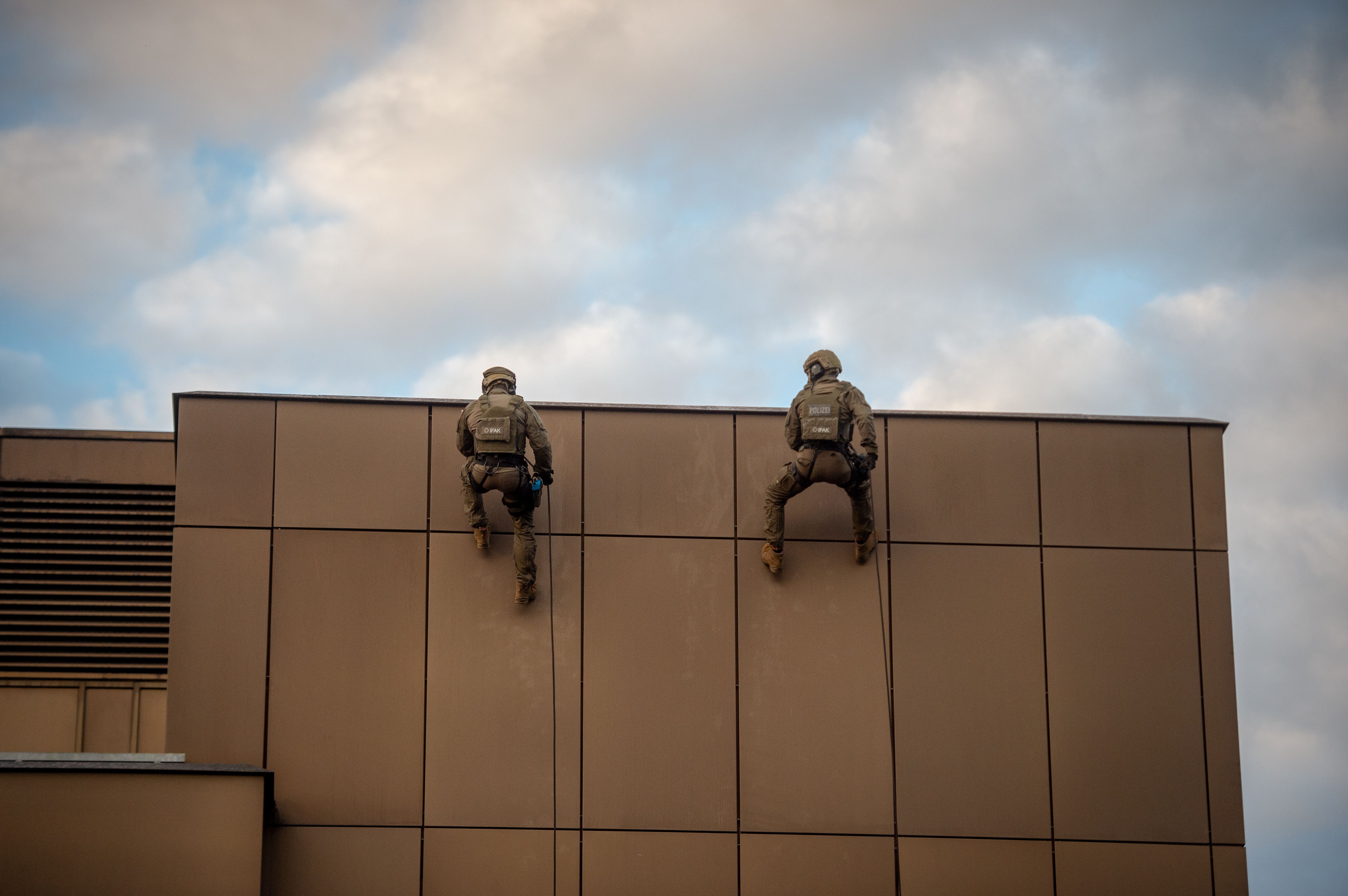 Die Spezialeinheit seilt sich vom Dach über die Gebäudefassade zum Einsatzort hinunter.