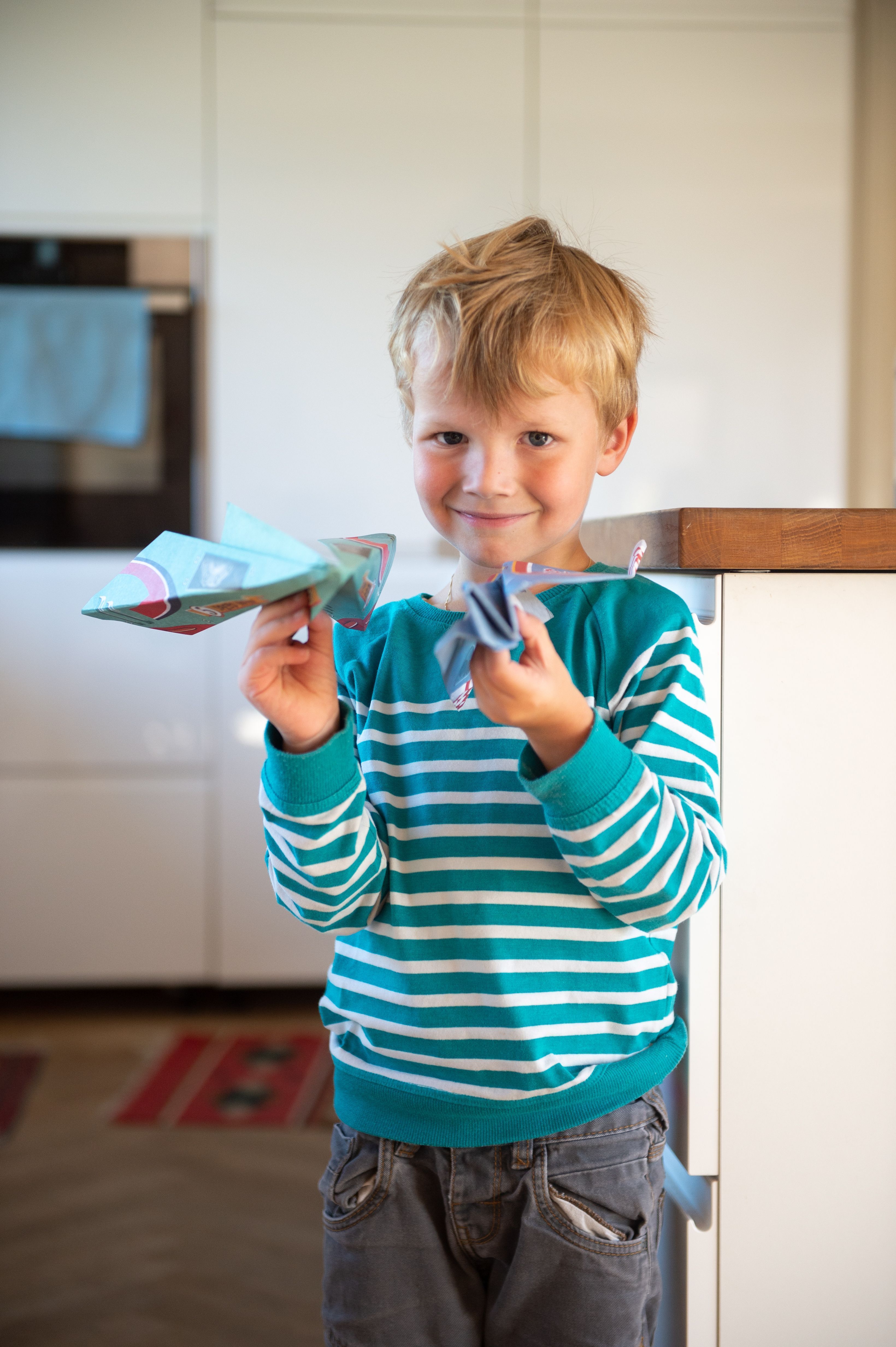 Jakob zeigt stolz seine Papierflieger. 