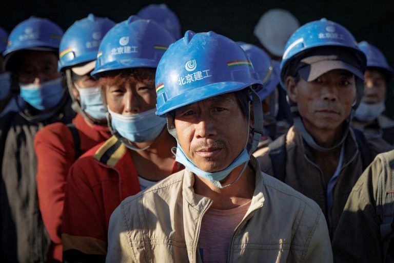Arbeiter versammeln sich zum Schichtbeginn auf der Baustelle des neuen Fußballstadions in Peking, China. Reuters