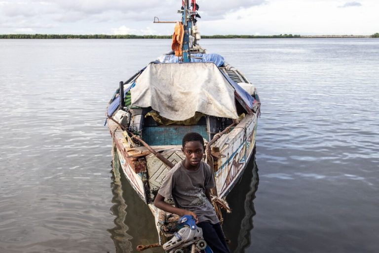 Beim Casamance-Fluss in der Stadt Ziguinchor im Senegal lehnt sich ein junger Bursche an ein kleines Schiff. AFP