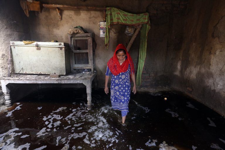 Eine Frau blickt sich in ihrem überfluteten Haus in Shikapur, Pakistan, um. Über 1000 Menschen kamen bei den Überschwemmungen ums Leben. AP
