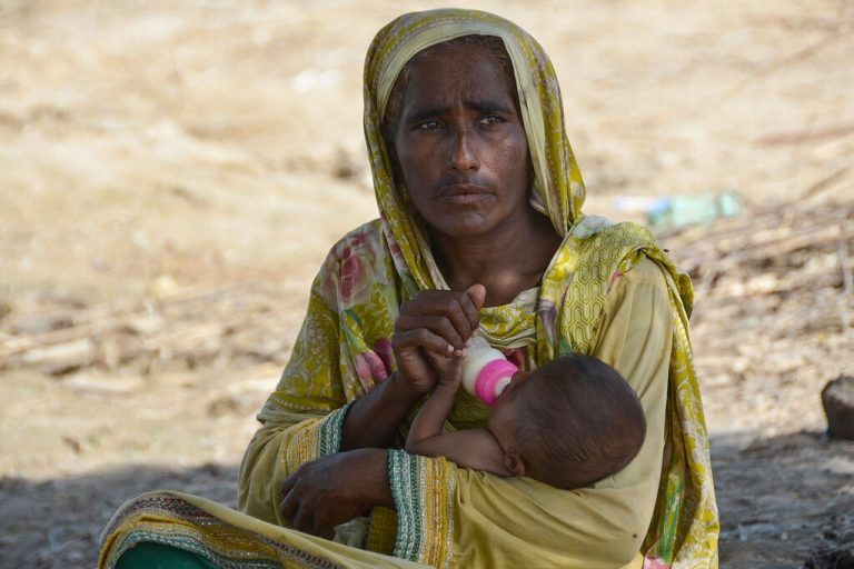 Eine von der verheerenden Flut in Pakistan vertriebene Frau, füttert ihr Kind in einem provisorischen Lager in Jaffarabad. Die Hungersnot wird von Tag zu Tag größer – und Infektionskrankheiten breiten sich in den Lagern aus. afp