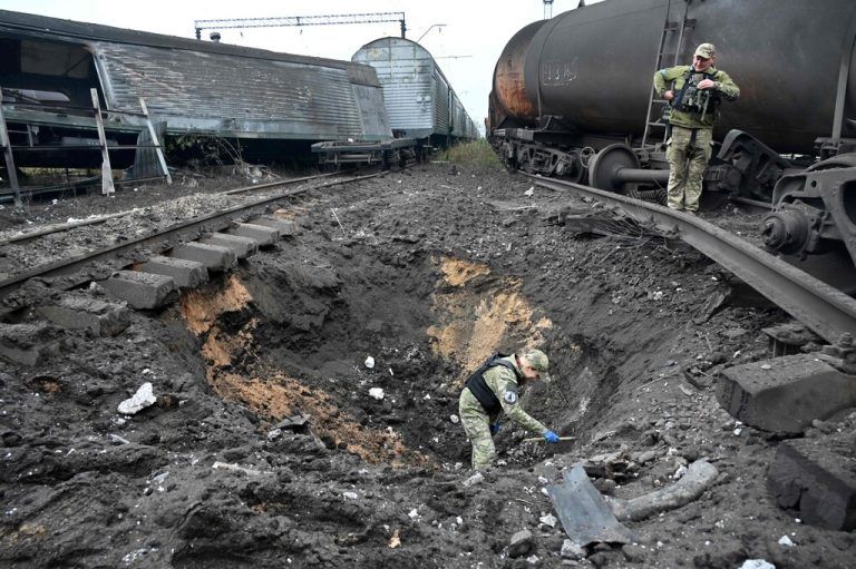 Nach einem Raketeneinschlag auf einem Güterbahnhof in Charkiw untersuchen Experten den Krater. AP