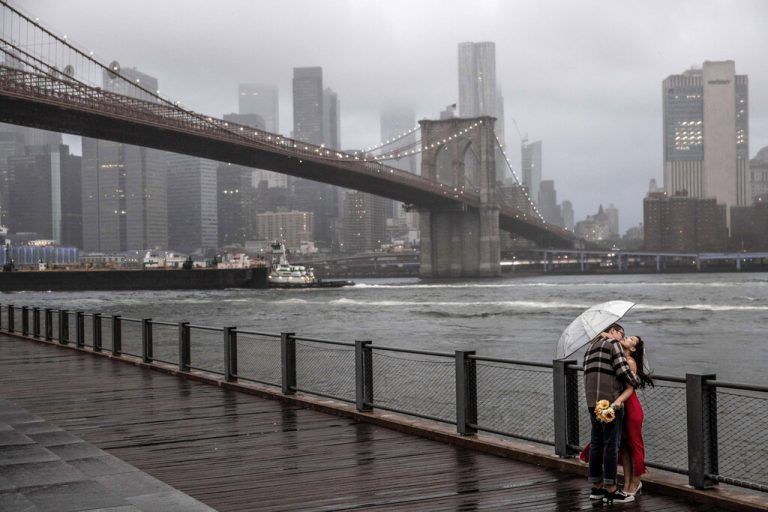 Die Brooklyn Bridge von New York am verregneten Wochenende: Kein Hindernis für dieses Paar am East River. AP