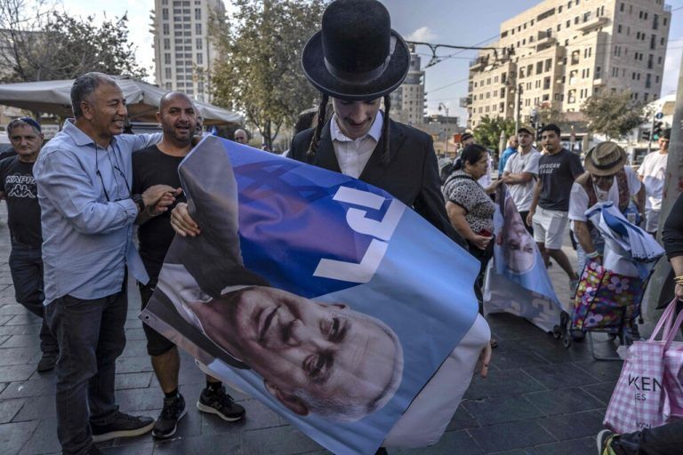 Ein ultraorthodoxer Jude hält ein Plakat des ehemaligen israelischen Ministerpräsidenten Benjamin Netanjahu während einer Wahlkampfveranstaltung. AFP