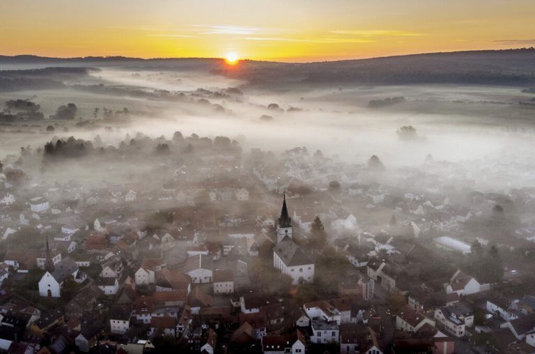 Eine dünne Nebeldecke überzieht die Landschaft bei Wehrheim in Hessen, nahe Frankfurt. Darüber geht die Sonne auf. AP