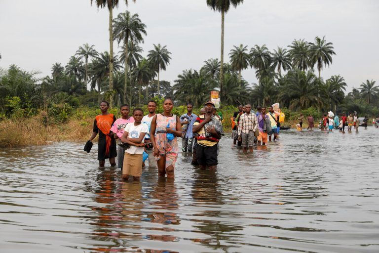 In Rivers State im Süden Nigerias waten Menschen durch eine überflutete Gegend. Reuters
