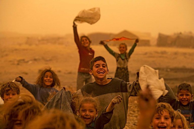Kinder spielen inmitten eines Sandsturms im Flüchtlingslager Sahlah al-Banat in Nordsyrien. AFP