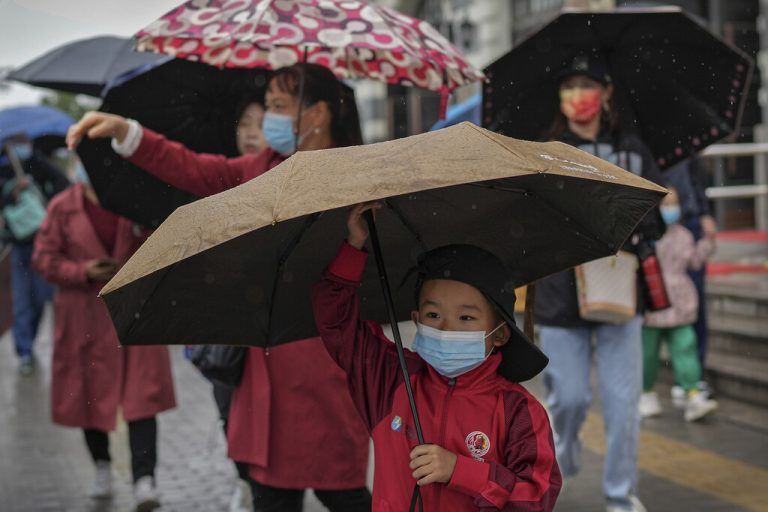 Mit Maske und Schirm hat ein junger Bub den Tiananmen-Platz in der chinesischen Hauptstadt Peking besucht. AP
