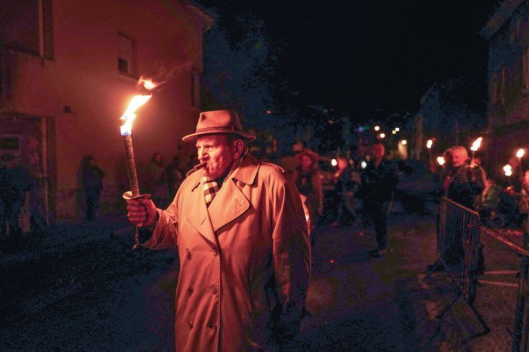 Ein Mann hält in den Straßen von Beaujeu, in der Region Beaujolais, eine Kerze beim traditionellen Fest „Le Sarmentelles“, das den Beginn der Weinedition „Beaujolais Nouveau“ 2022 ankündigt. AFP