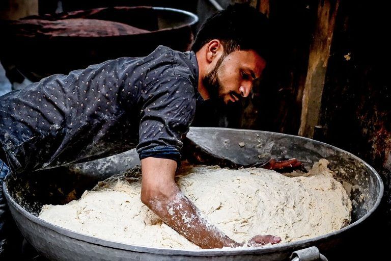 In einer Bäckerei in Neu Delhi knetet ein Mitarbeiter Teig, um Roti zuzubereiten - eine in Indien beliebte Brotform. AFP