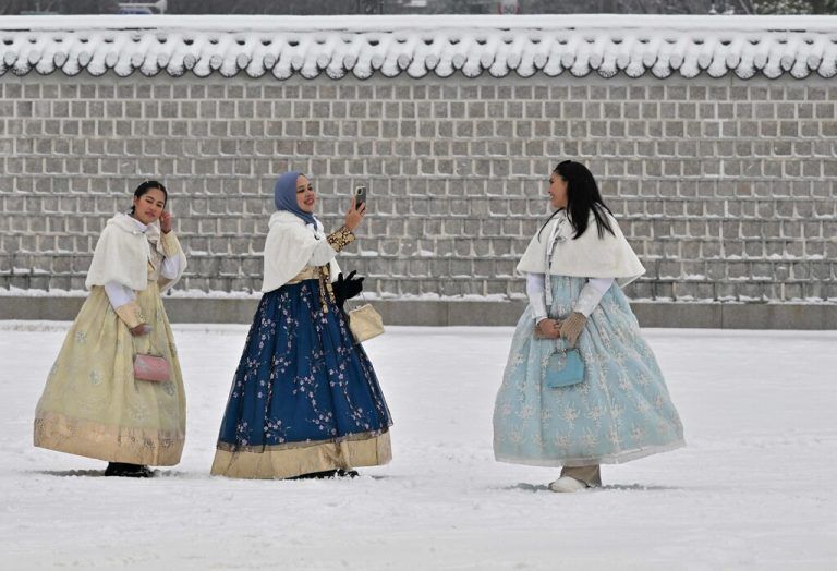 Besucherinnen im traditionellen Hanbok machen Fotos im schneebedeckten Gyeongbokgung-Palast in Seoul, Südkorea. AFP