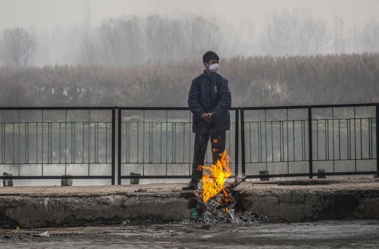 Ein Bub, der auf den Schulbus wartet, wärmt sich in Srinagar, in dem von Indien kontrollierten Kaschmir, seine Hände an einem Feuer. AP