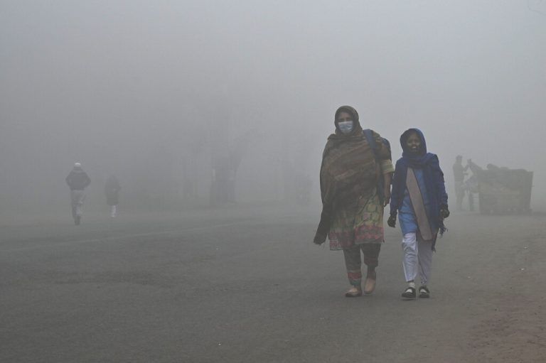 Eine Schülerin wird bei nebligem Wetter im pakistanischen Lahore von ihrer Mutter zur Schule begleitet. AFP