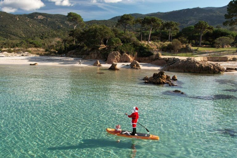 Eine weihnachtlich verkleidete Frau steuert in der Nähe des Strandes Mare e Sol auf der französischen Insel Korsika ein Paddleboard. AFP