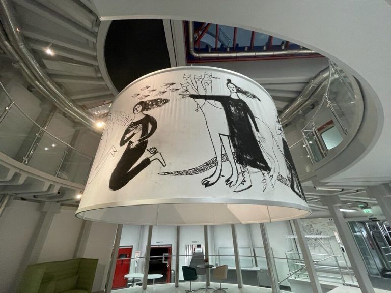 Bianca Tschaikner zeigt mit einem Panoramabild, welches das Foyer im Funkhaus optisch aufwertet, auf.FRO/Fritsch