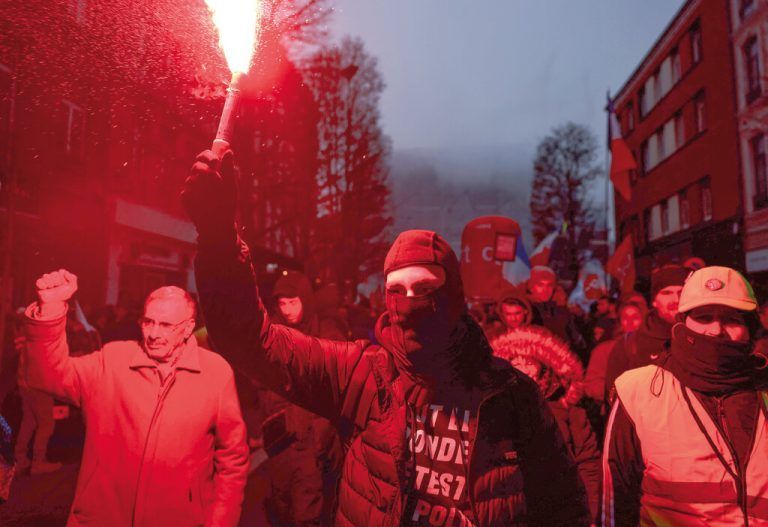 Ein Demonstrant hält bei einer Kundgebung in Lille, Nordfrankreich, eine Leuchtfackel hoch, während er gegen die Anhebung des Rentenalters von 62 auf 64 protestiert. AFP