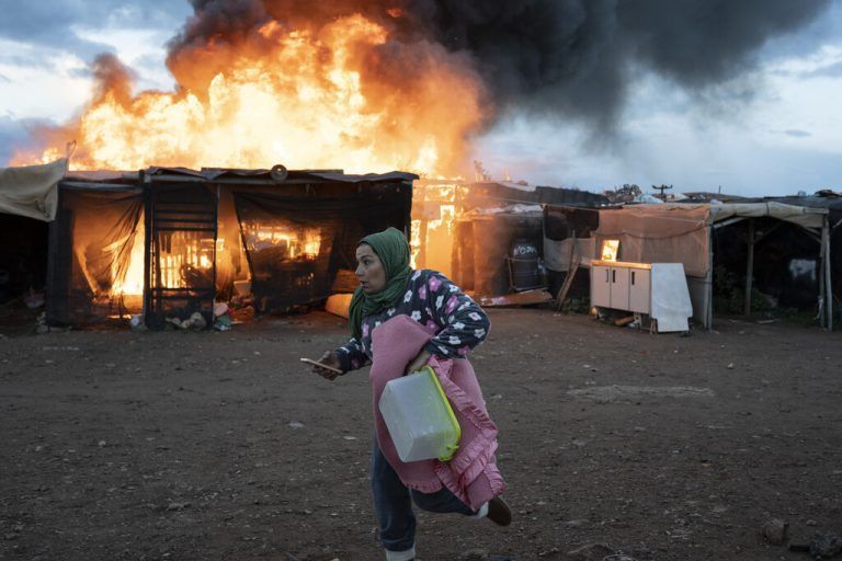 Eine Frau flieht vor einem Feuer in einem Flüchtlingslager in Almeria, in Südspanien. Die meisten Bewohner arbeiten als Erntehelfer. AP