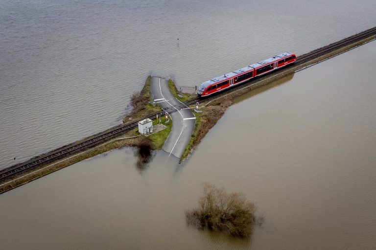 Für diesen Regionalzug geht sich die Überfahrt der gefluteten Felder noch aus: Die Straße in der Nähe von Frankfurt steht bereits unter Wasser. AP