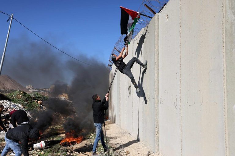 Palästinensische Demonstranten platzieren während einer Demonstration im besetzten Westjordanland eine Nationalflagge auf Israels umstrittener Grenzmauer. AFP
