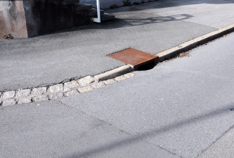 Die kantigen Randsteine werden beim Straßenumbau durch die flache Doppelpflasterung ersetzt.