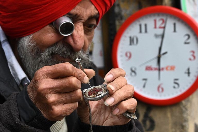 Ein indischer Uhrmacher repariert eine Uhr an seinem Stand an einer Straße in Amritsar in Indien. AFP