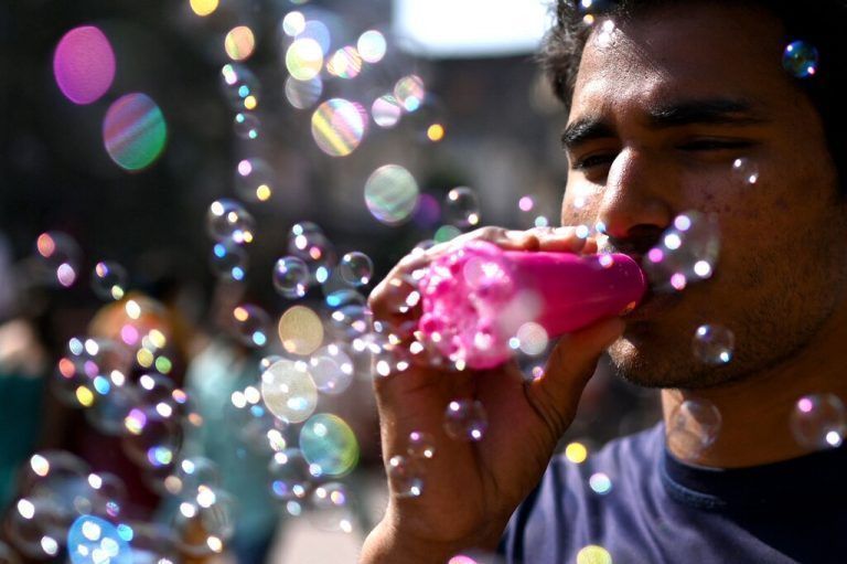 Ein Straßenhändler, der Seifenblasen verkauft, wartet am Straßenrand in der Altstadt von Neu-Delhi in Indien auf Kunden. AFP