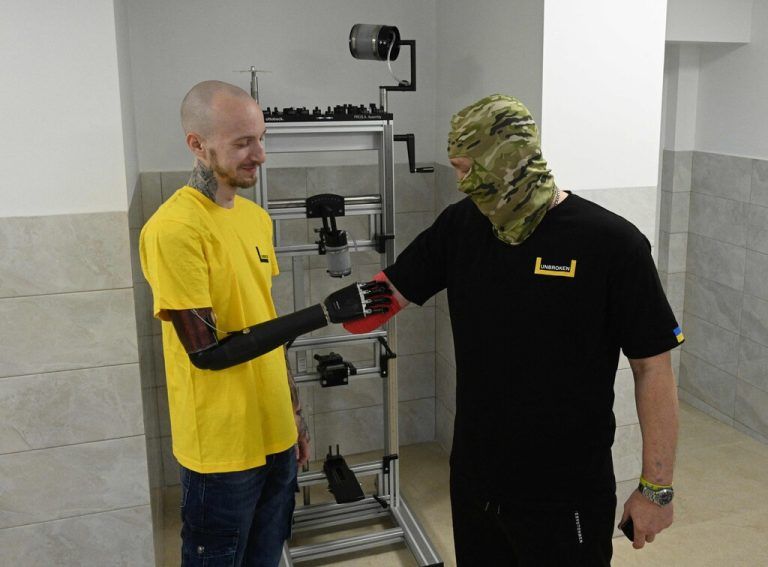 Der ukrainische Soldat Mykyta (l.) und ein Kollege begrüßen sich im Rehabilitationszentrum „Unbroken“ in der Stadt Lwiw. AFP