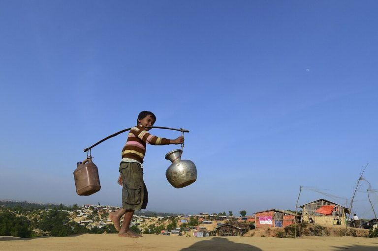 Ein Rohingya-Kind kehrt zu seiner provisorischen Unterkunft zurück, nachdem es im Flüchtlingslager in Bangladesch Wasser gesammelt hat. AFP