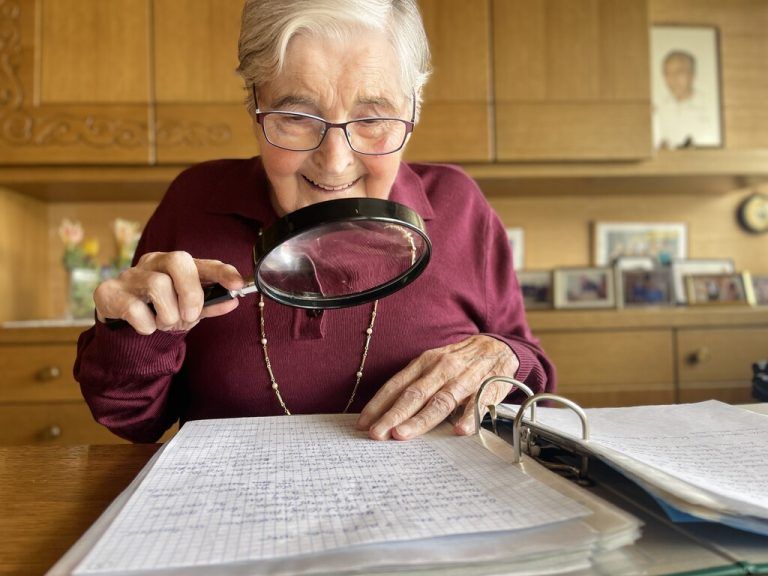 Annelies Herburger mit dem handschriftlichen Manuskript. Beim Lesen hilft der Seniorin eine große Lupe.
