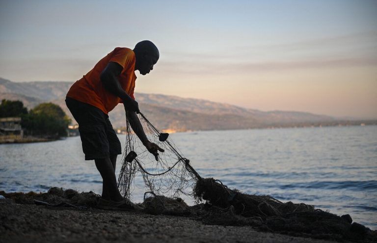 Ein Mann repariert in Petit-Goâve in Haiti sein Fischernetz. Trotz Meeresverschmutzung wird in dem Ort viel gefischt. AFP