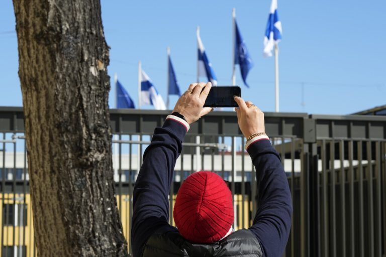 Eine Person fotografiert in Helsinki Finnland- und NATO-Fahnen. AP