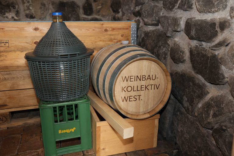 Glasballon und Barrique-Fass im Keller.