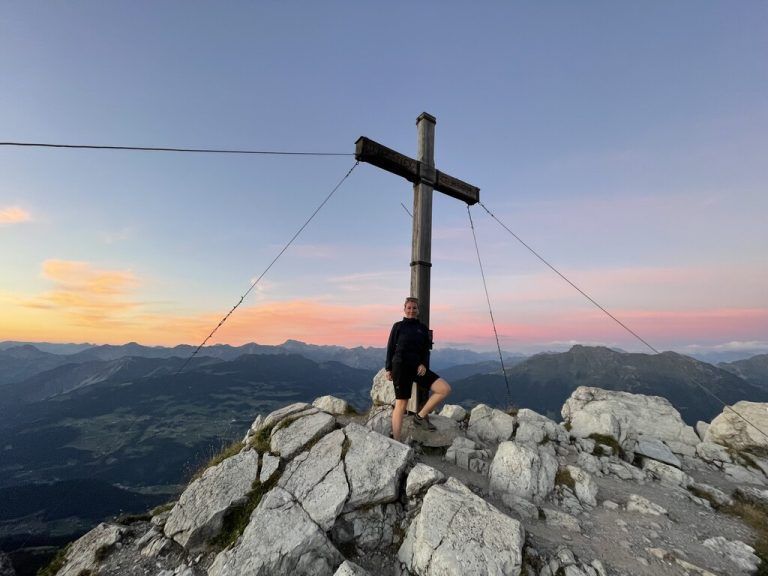 Am Berg, im Schatten eines Gipfelkreuzes, kann die vielbeschäftigte Geschäftsfrau richtig abschalten.