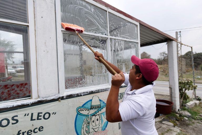 Fenster eines Restaurants in San Nicolás de los Ranchos, Mexiko, werden von der Asche des Vulkans Popocatépetl gereinigt. AFP