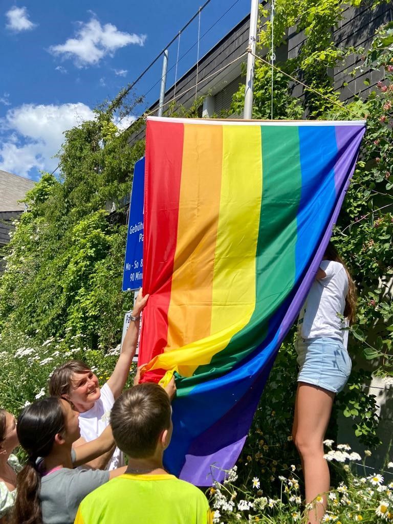 Nach der Projektpräsentation wurde die Regenbogenfahne vor dem Gemeindeamt gehisst. Vizebgm. Angelika Moosbrugger (l.) unterstützte die Aktion tatkräftig.