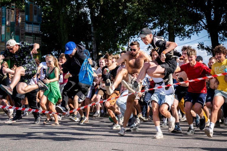 Besucher des Roskilde-Musikfestivals stürmen bei der Eröffnung auf das Festivalgelände. Das Roskilde-Festival in Dänemark ist eines der größten Festivals in Europa. AFP