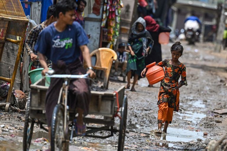 Ein Rohingya-Mädchen läuft eine schlammige Straße in einem Flüchtlingslager der indischen Hauptstadt Neu-Delhi entlang. AFP