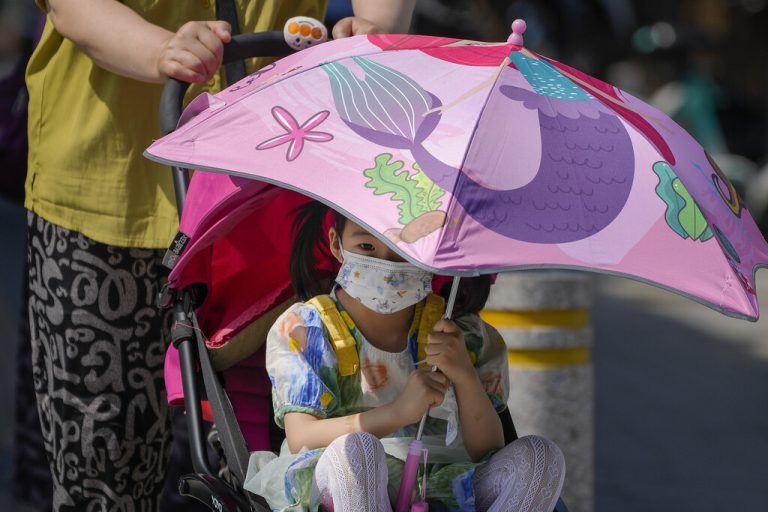Mit einem Schirm schützt sich dieses Mädchen in der chinesischen Hauptstadt Peking während einer Hitzewelle vor der Sonne. AP