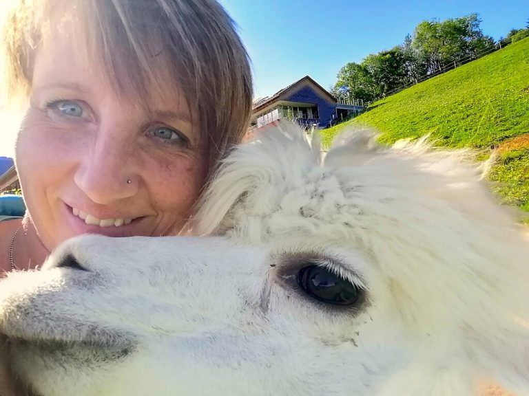 Sandra kuschelt mit ihren Alpakas.
