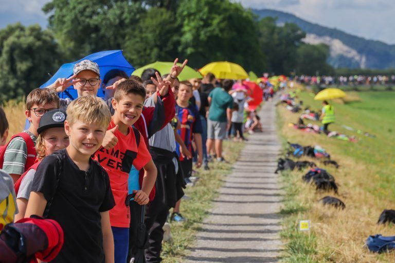 Eine schier endlose Schlange an Schulkindern bezog auf dem Rheindamm zwischen Lustenau Wiesenrain bis nach Diepoldsau Position. Grund: 100 Jahre Rheindurchstich Diepoldsau. <span class="copyright">VN/Steurer</span>