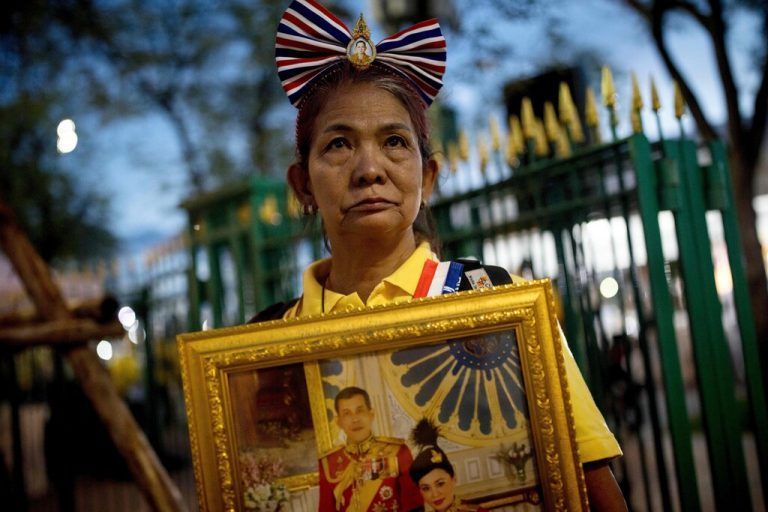 Anlässlich des 71. Geburtstags von Thailands König Maha Vajiralongkorn hät eine Royalistin ein Portrait von ihm in der Hand. AFP