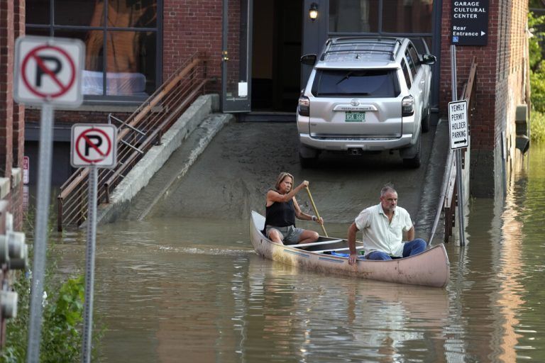 Bewohner paddeln in Montpelier über eine überflutete Straße. AP