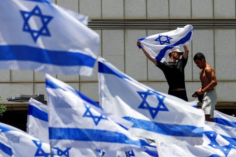 Demonstranten schwenken in Tel Aviv israelische Flaggen. Reuters