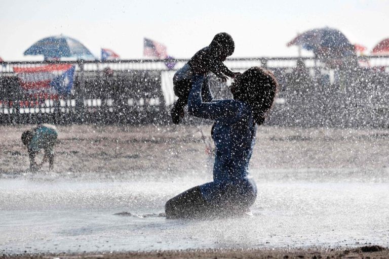 Mutter und Kind kühlen sich an einem heißen Nachmittag im New Yorker Stadtteil Brooklyn unter einem Brunnen auf Coney Island ab. AP