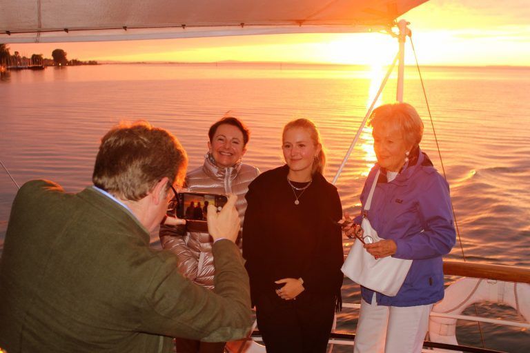 Erinnerungsfoto an eine atemberaubende Stimmung – Martin Benger hält seine Familie – Gattin Karin, Tochter Lina, Mutter Lore – im Sonnenuntergang auf dem Bodensee fest.<br>