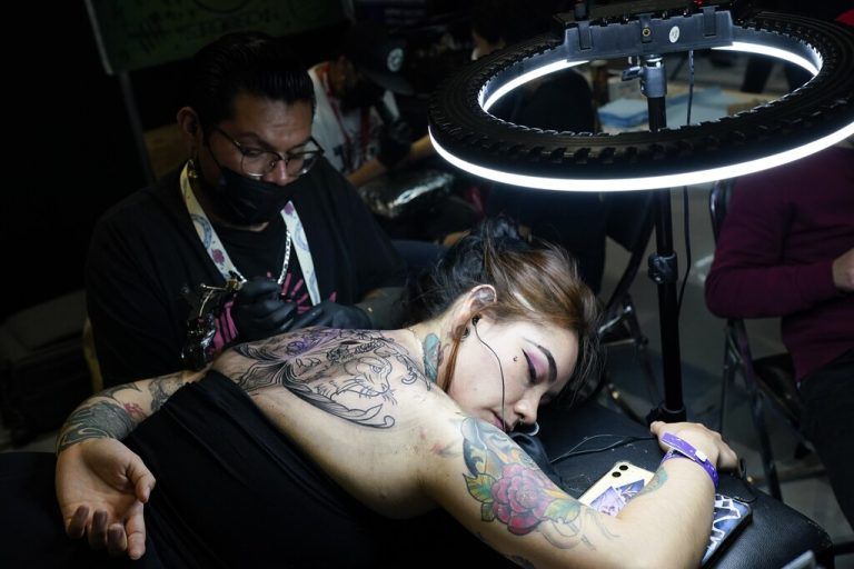 Bei einer Tattoo-Convention in Mexiko-Stadt arbeitet ein Tätowierer auf dem Rücken einer Frau. AP