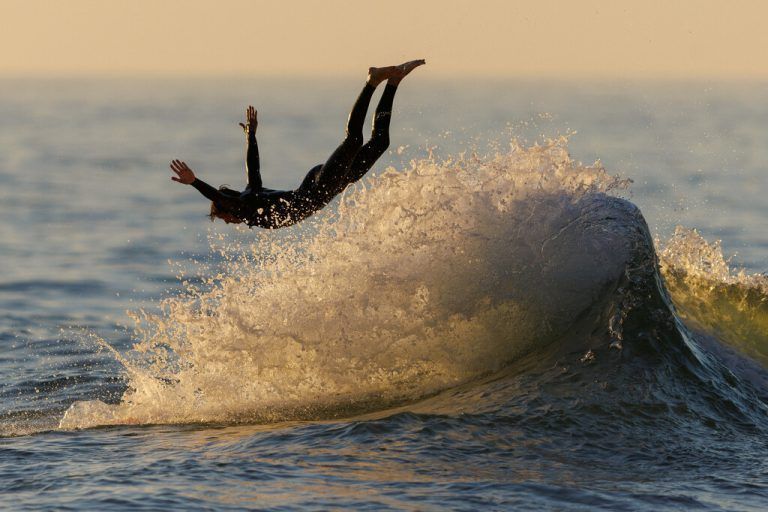 Bei Sonnenuntergang in Encinitas im US-Staat Kalifornien springt ein Surfer von seinem Brett ins Meer. Reuters