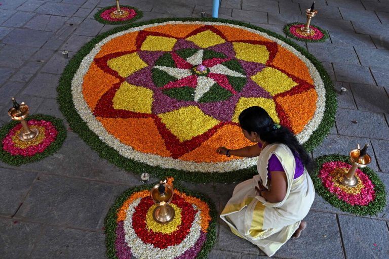 Eine gläubige Frau bereitet Pookalam, ein traditionelles Blumenarrangement, für das „Onam“-Fest im Ayyappa-Tempel in Hyderabad vor. AFP