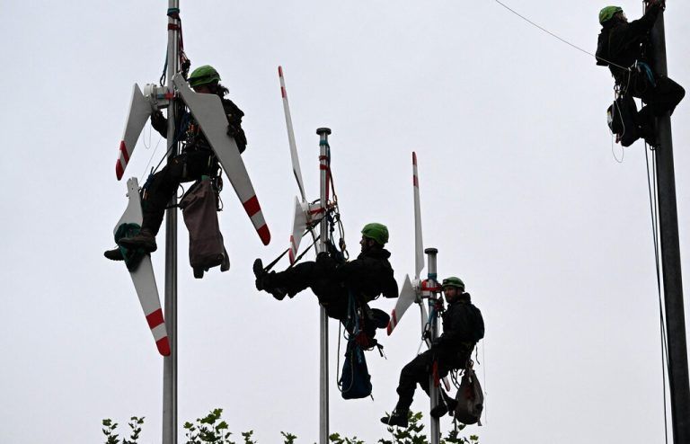 Greenpeace-Aktivisten hängen Windräder auf Fahnenmasten vor der Bayerischen Staatskanzlei in München auf. AFP